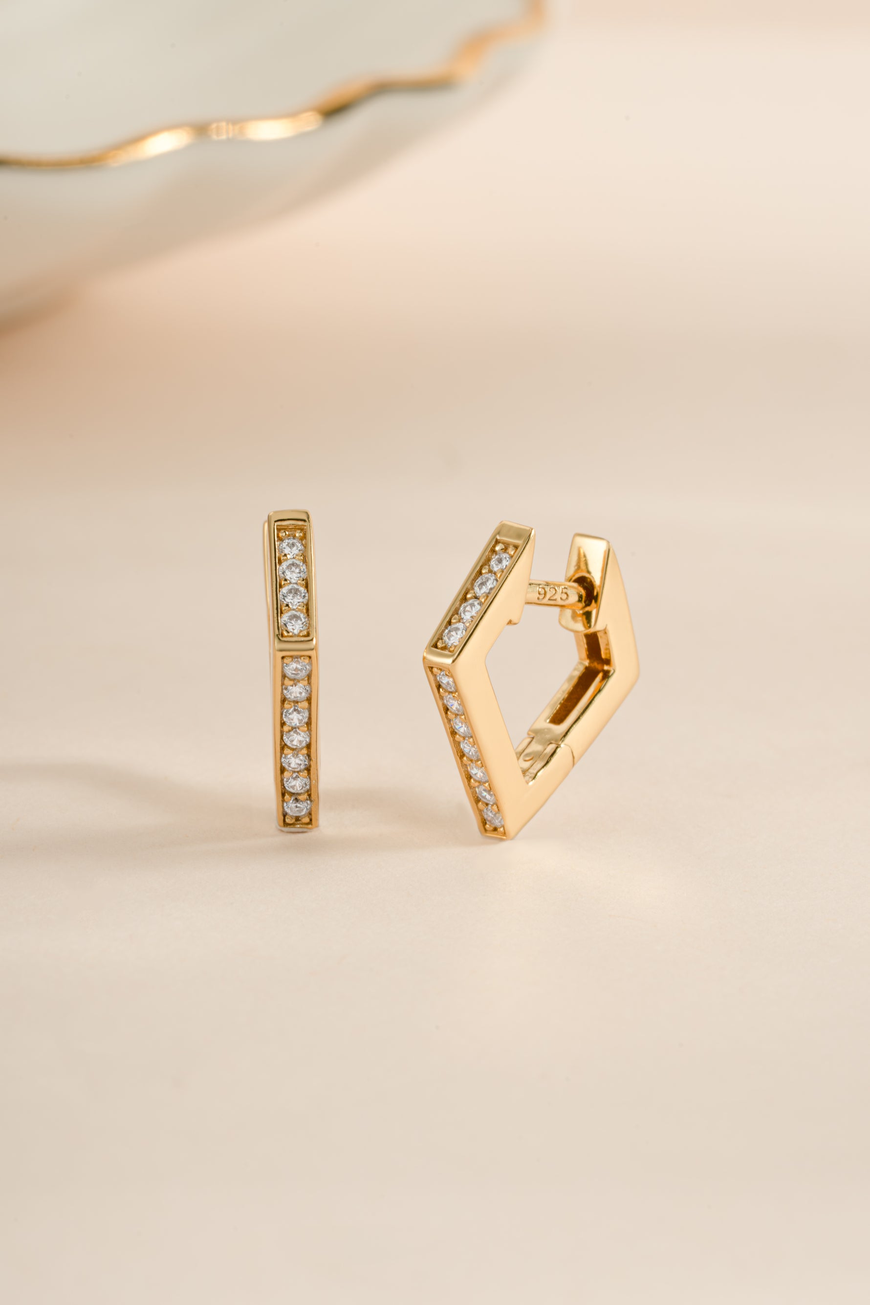 Gold geometric huggie earrings by Sami Jewels with sleek, modern design and secure hoop closure.