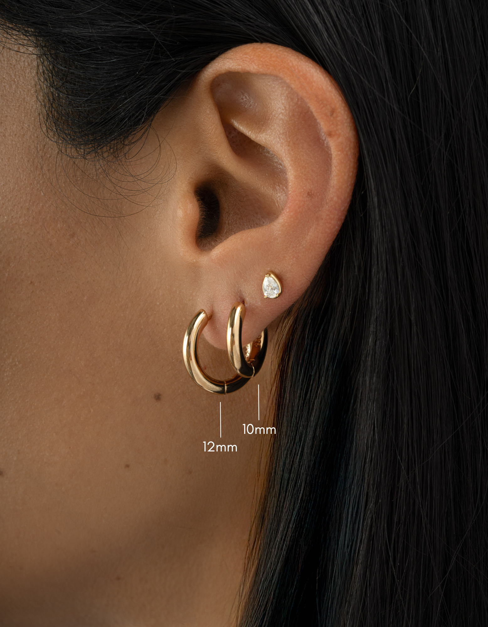 gold 12mm hoop earring and 10mm hoop earring on womens ear 