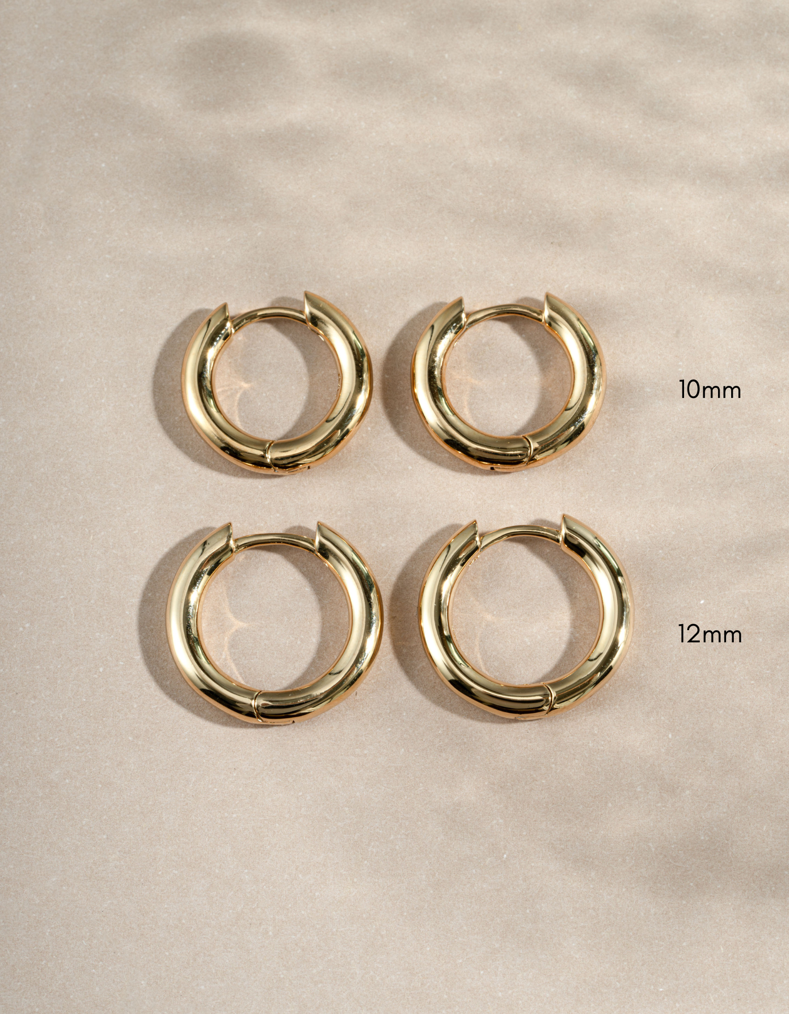 10mm gold hoops and 12mm gold hoops on a simple background