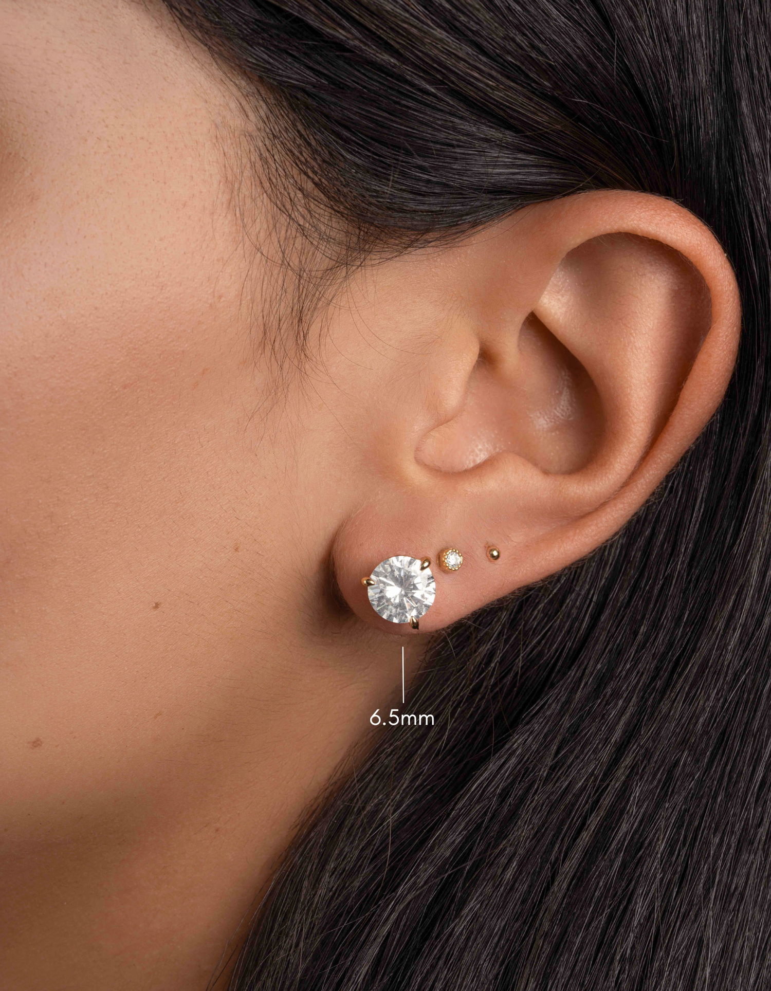 gold 6.5mm round solitaire diamond stud earring on womens ear