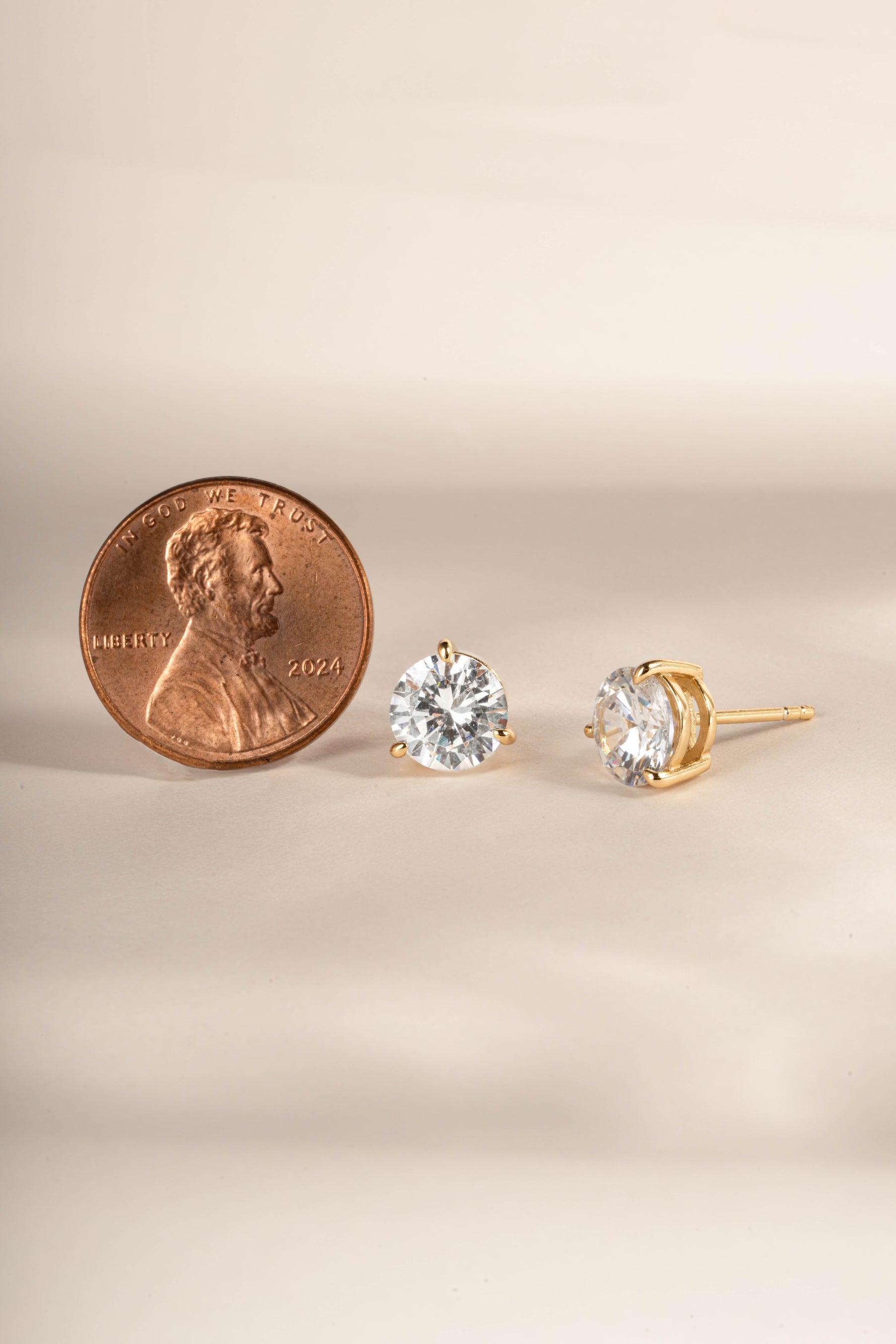 Gold 7.5mm round solitaire diamond stud earrings by Sami Jewels, showcasing sparkling single-diamond studs on a gold setting.