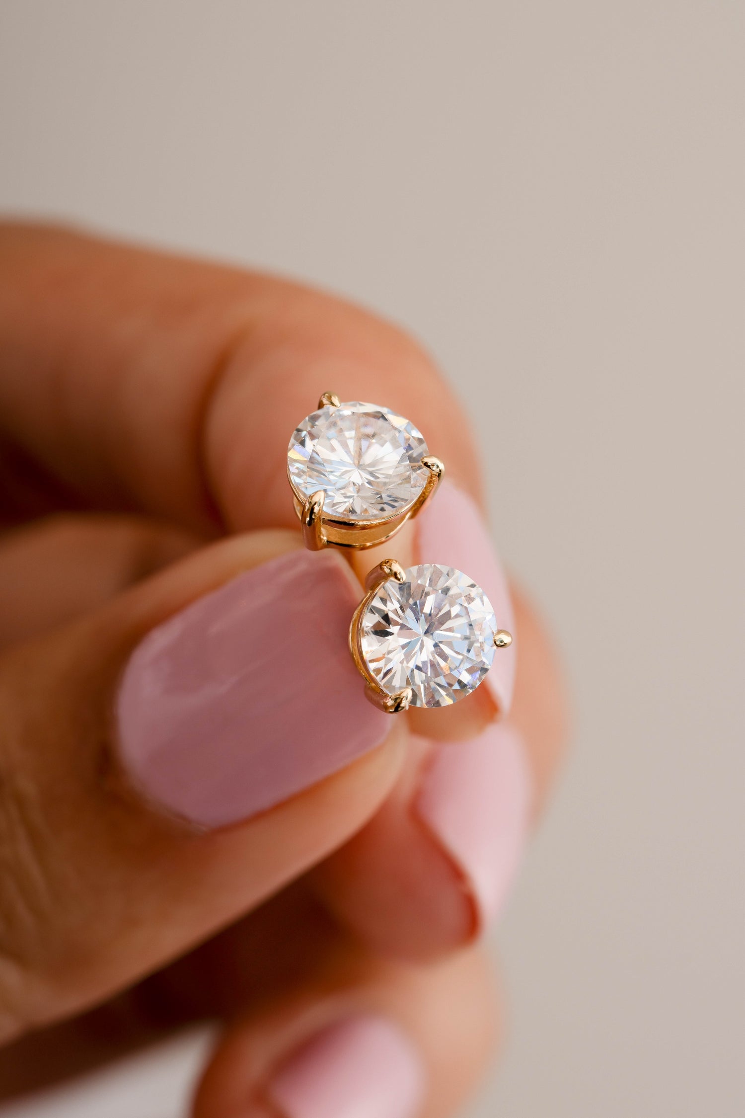Gold 8mm round solitaire diamond stud earrings by Sami Jewels, showcasing classic elegant jewelry with sparkling gemstones.