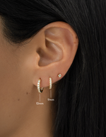 gold plated in and out studded huggies on womens ear, one 10mm hoop, and one 9mm hoop