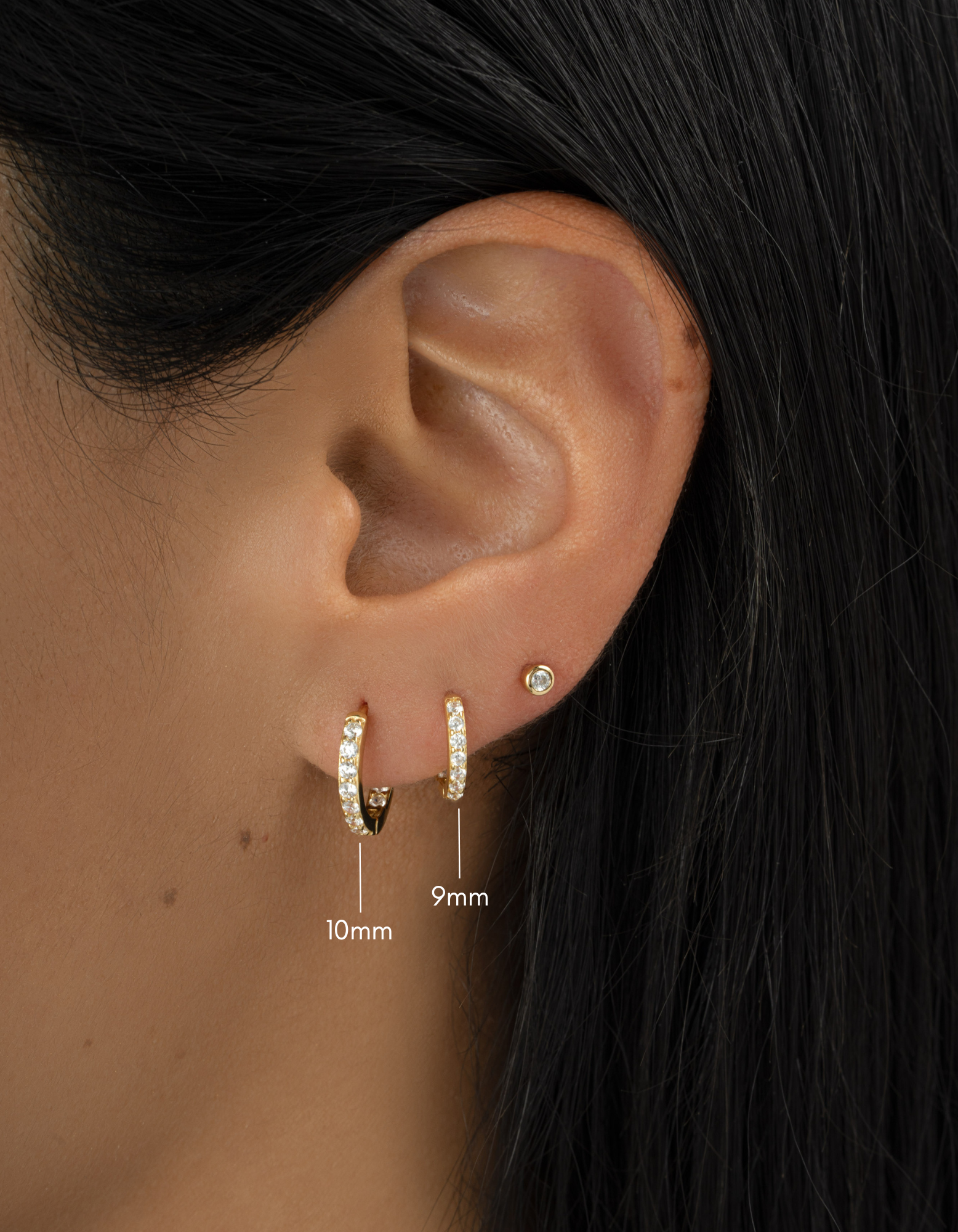 gold plated in and out studded huggies on womens ear, one 10mm hoop, and one 9mm hoop