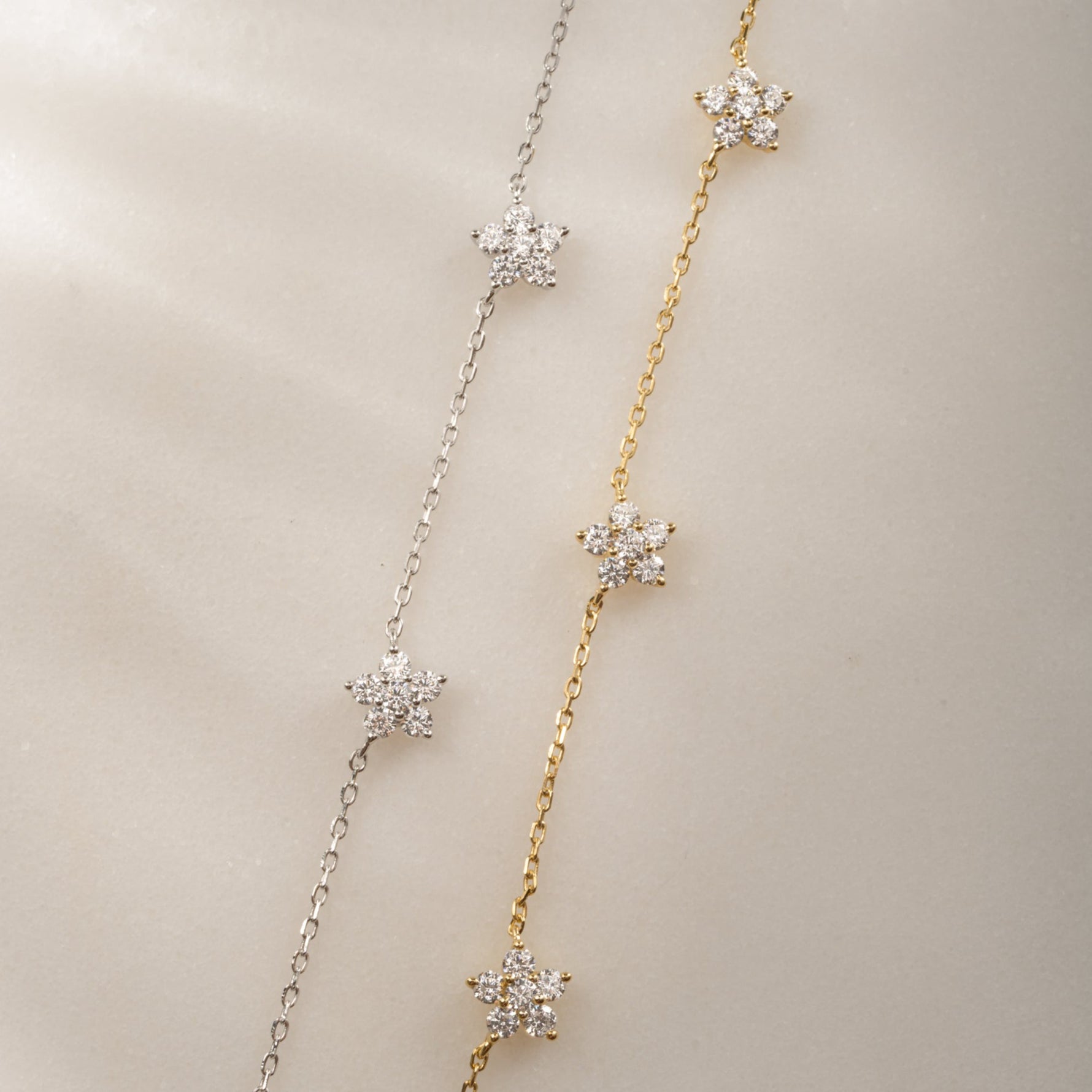 dainty diamond flower charms on delicate chain in 14k gold plated and sterling silver finishes.