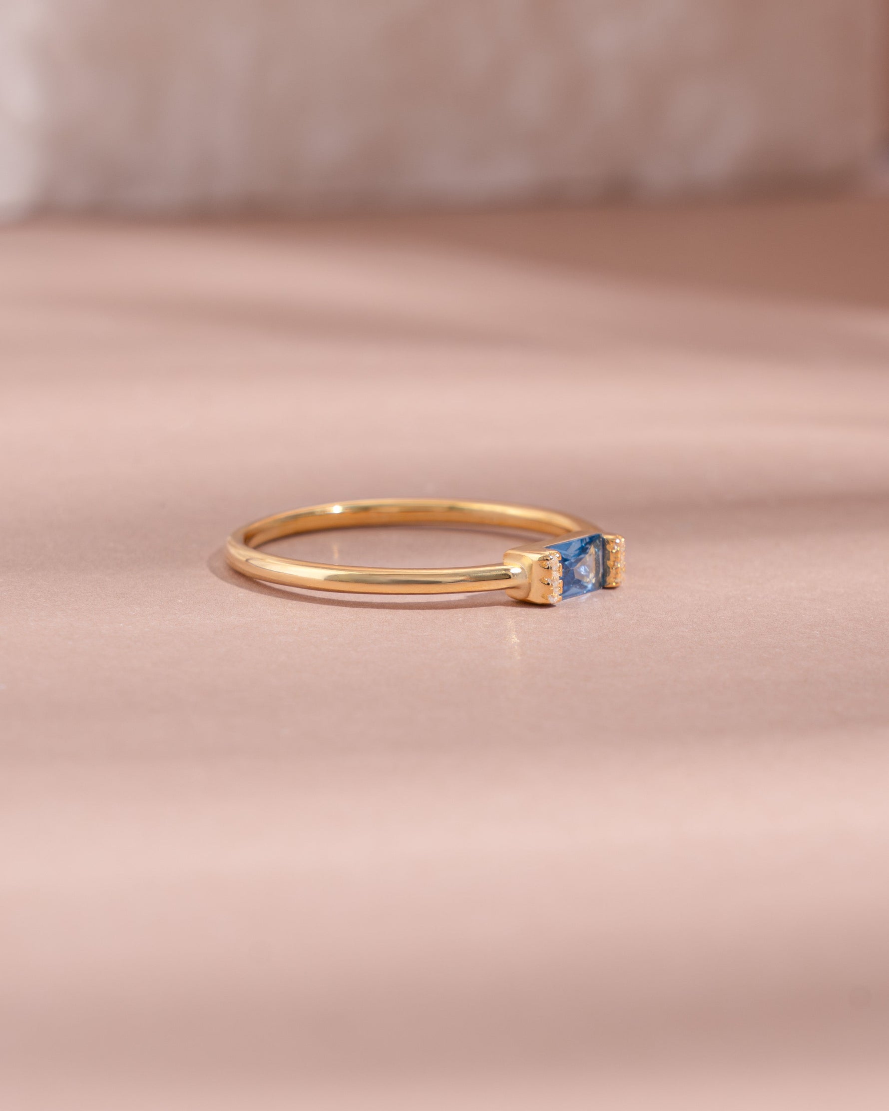 Gold aquamarine baguette ring with diamond accents, side view showcasing elegant design and gemstone details.