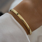 plain solid gold bangle on a wrist