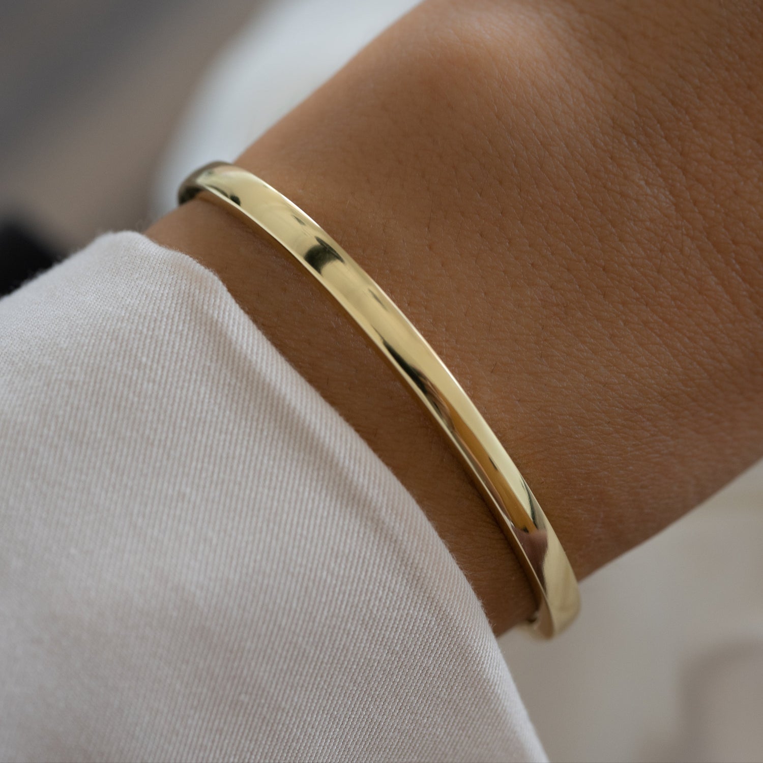 plain solid gold bangle on a wrist