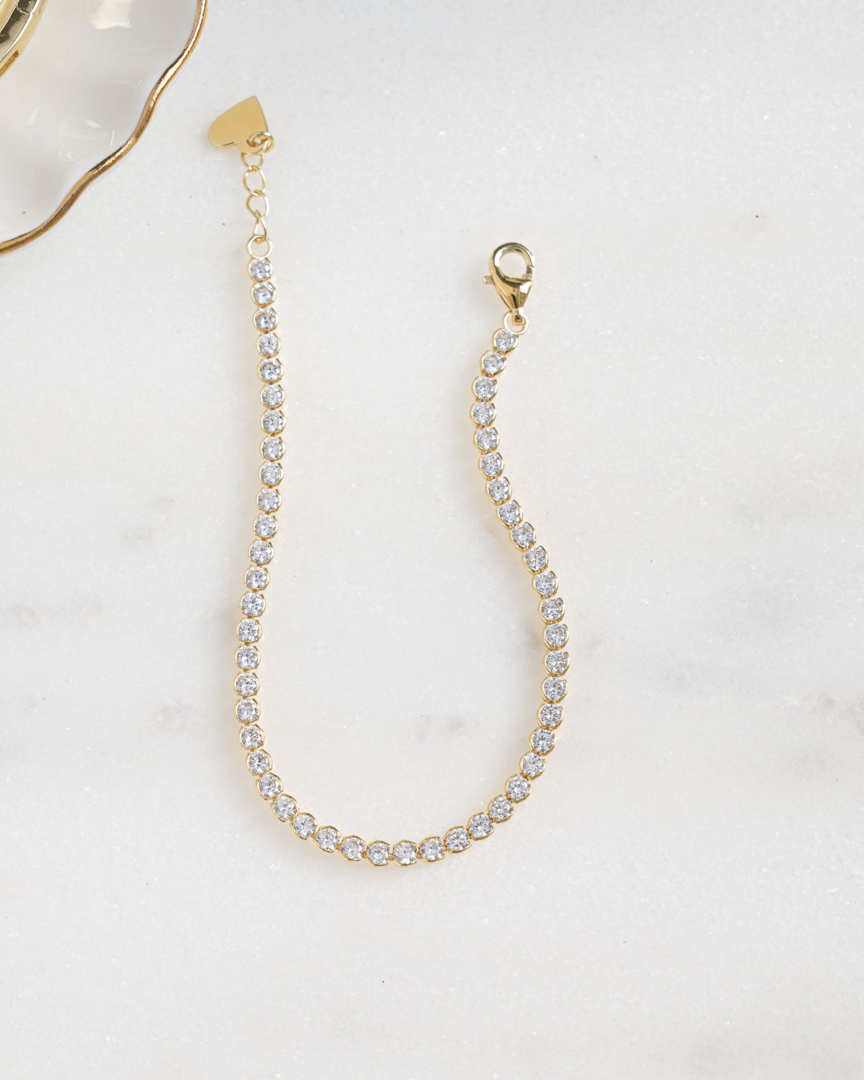 gold diamond round tennis bracelet neutral background