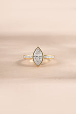 Gold bezel marquise ring with baguette band from Sami Jewels, featuring sparkling cubic zirconia stones in a elegant design.