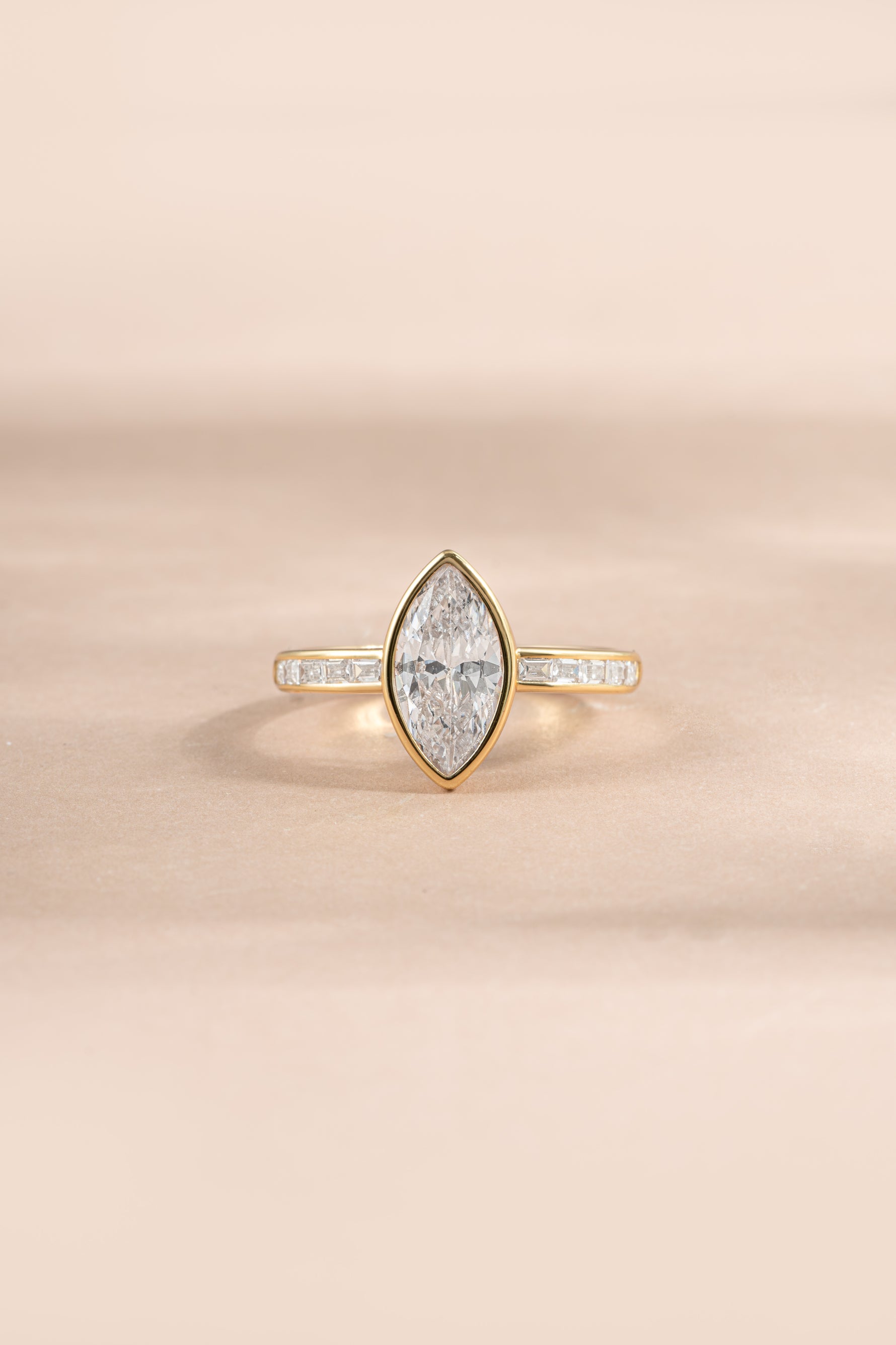 Gold bezel marquise ring with baguette band from Sami Jewels, featuring sparkling cubic zirconia stones in a elegant design.