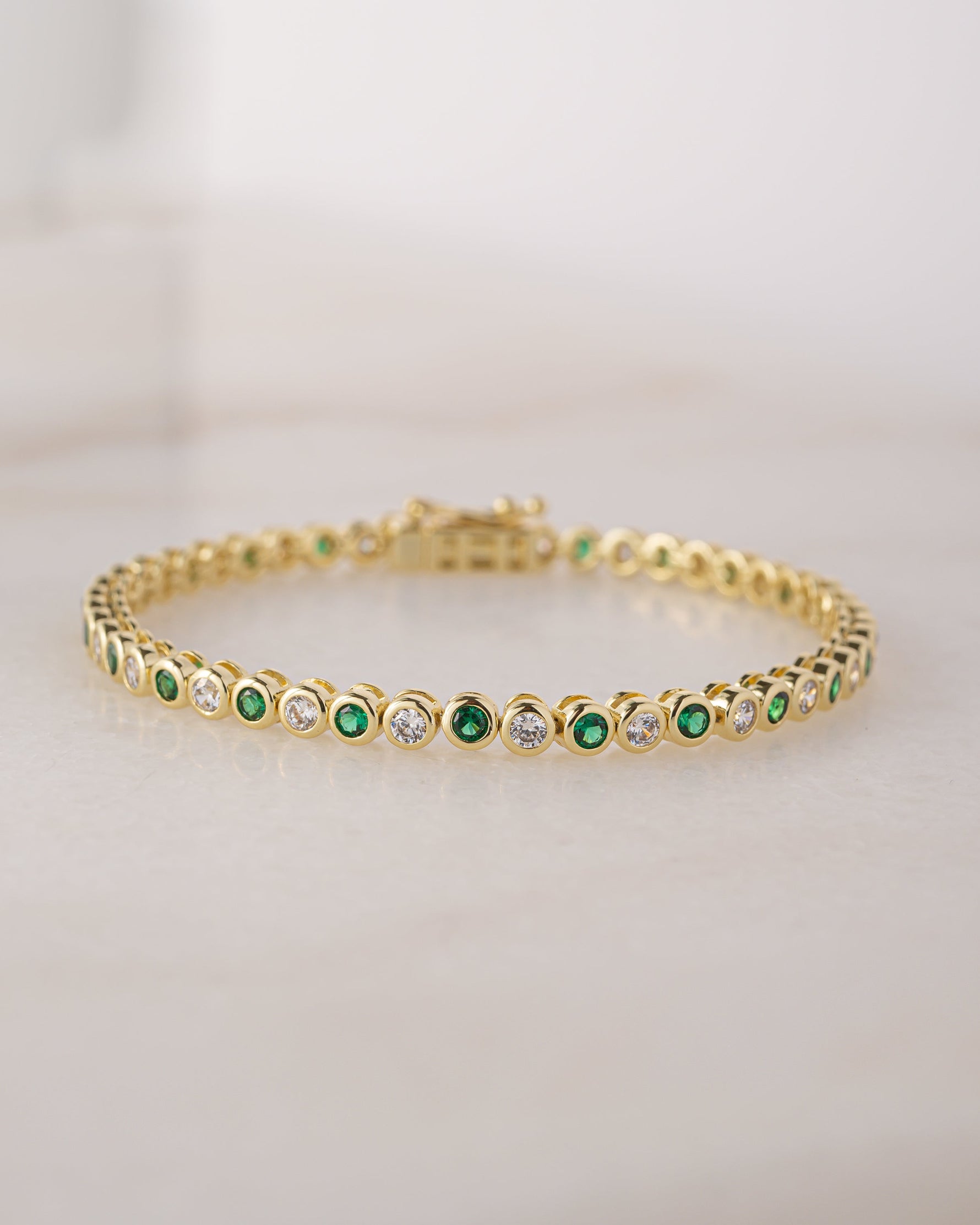 gold tennis bracelet with emerald green cubic zirconia stones