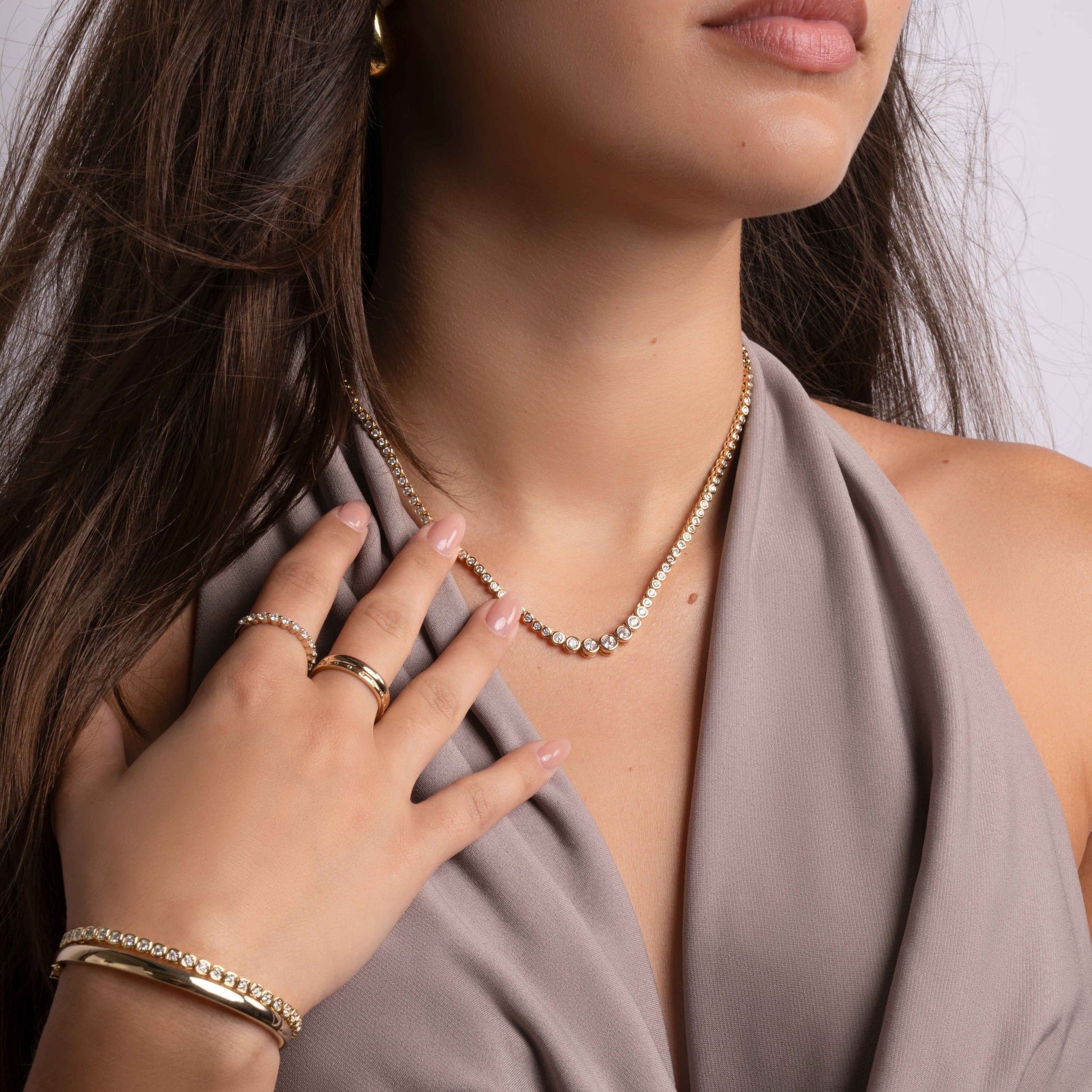 model wearing diamond choker with tennis chain design paired with gold diamond rings and dainty bracelets