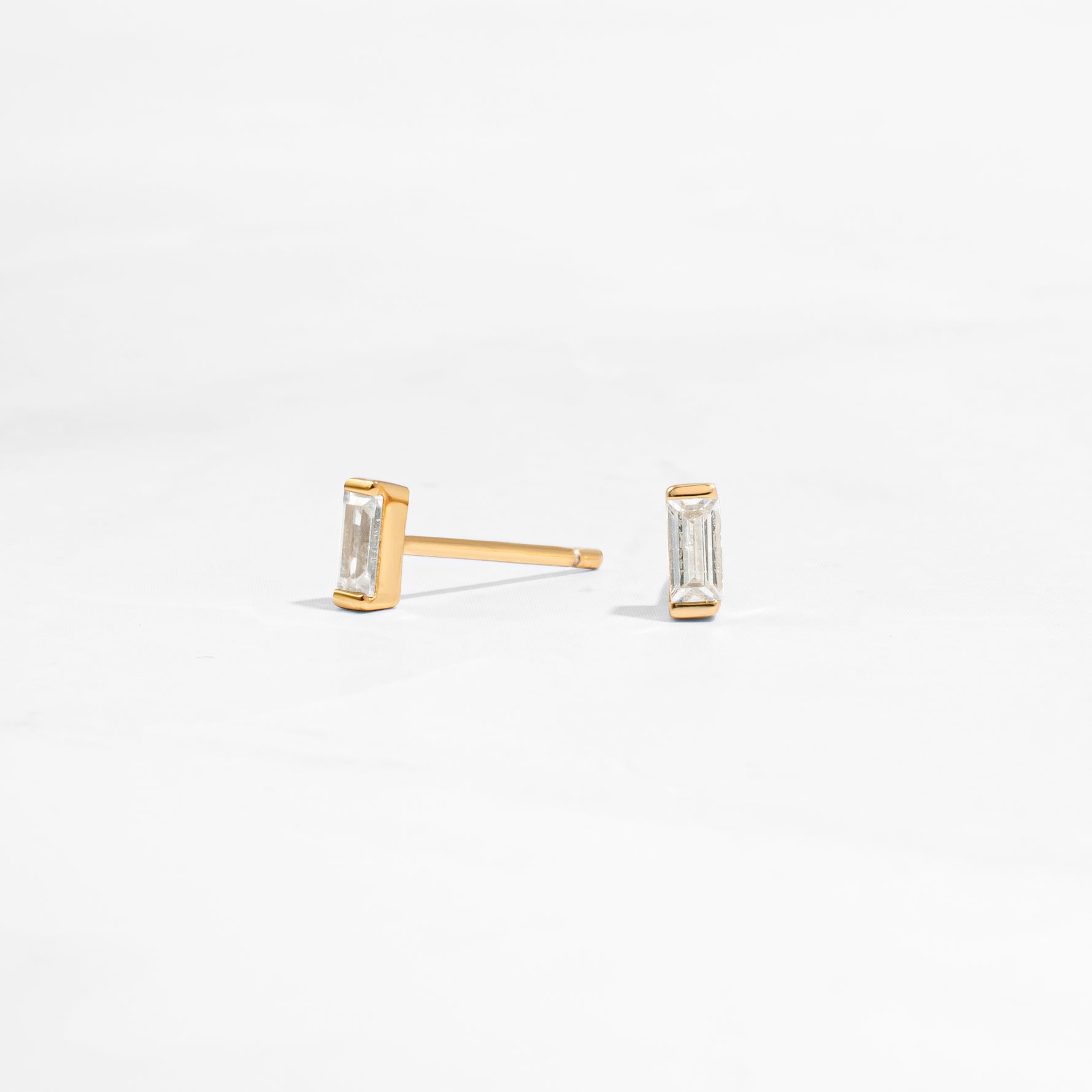 closeup image of minimalist gold earrings