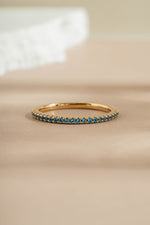 blue topaz gold eternity ring closeup