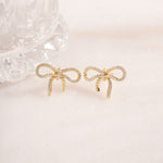 flat lay of gold earrings, highlighting its refined bow design