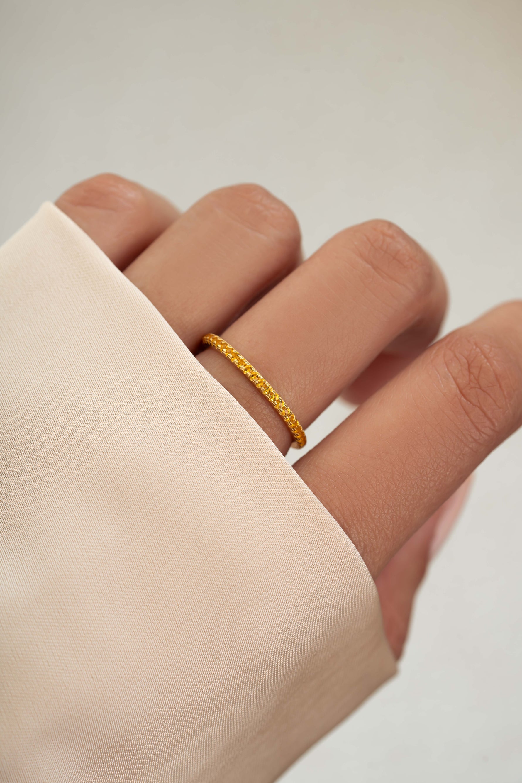 gold citrine birthstone eternity ring on womens hand