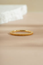 gold citrine birthstone eternity ring neutral background