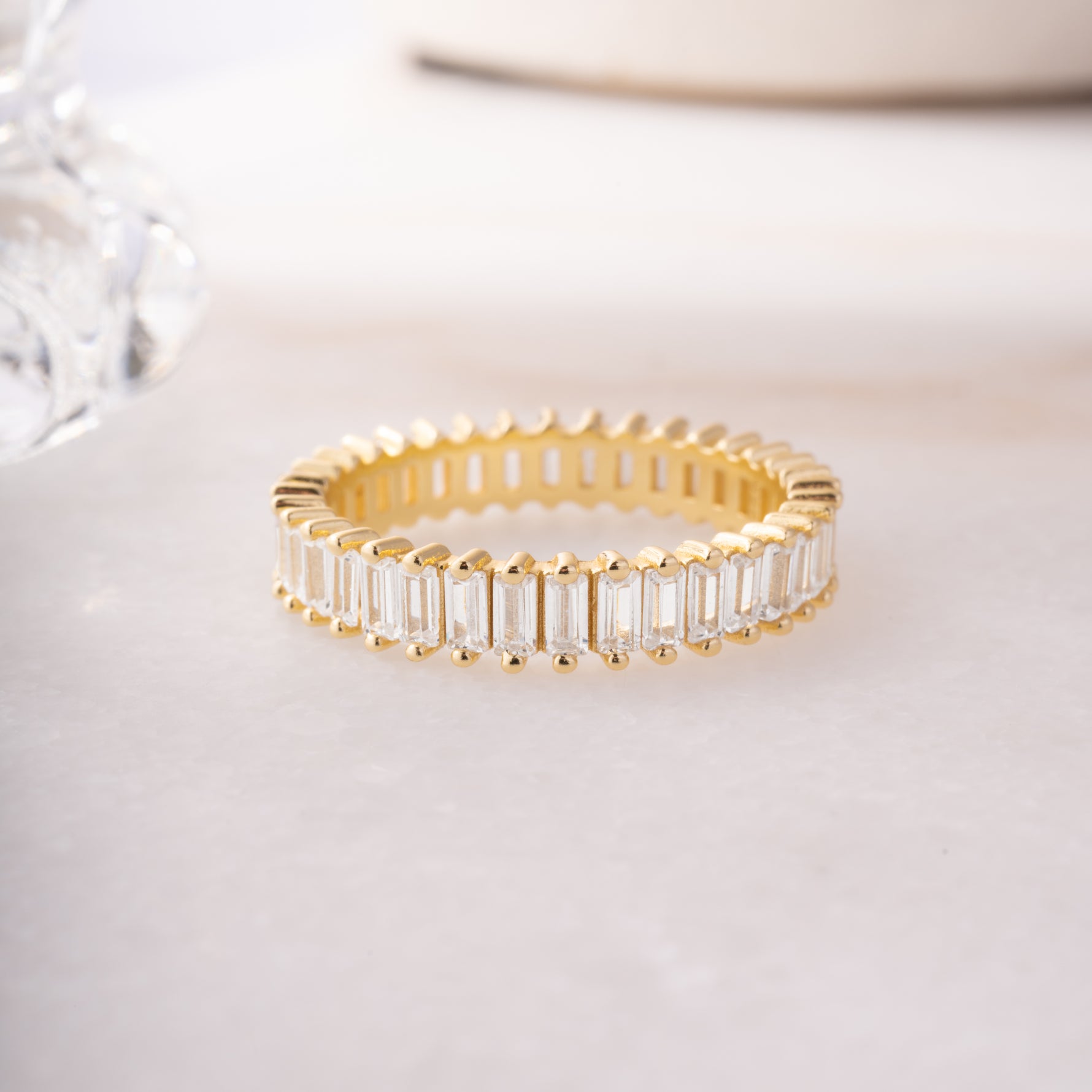 close up of a 14k gold ring , highlighting its intricate diamond baguette details