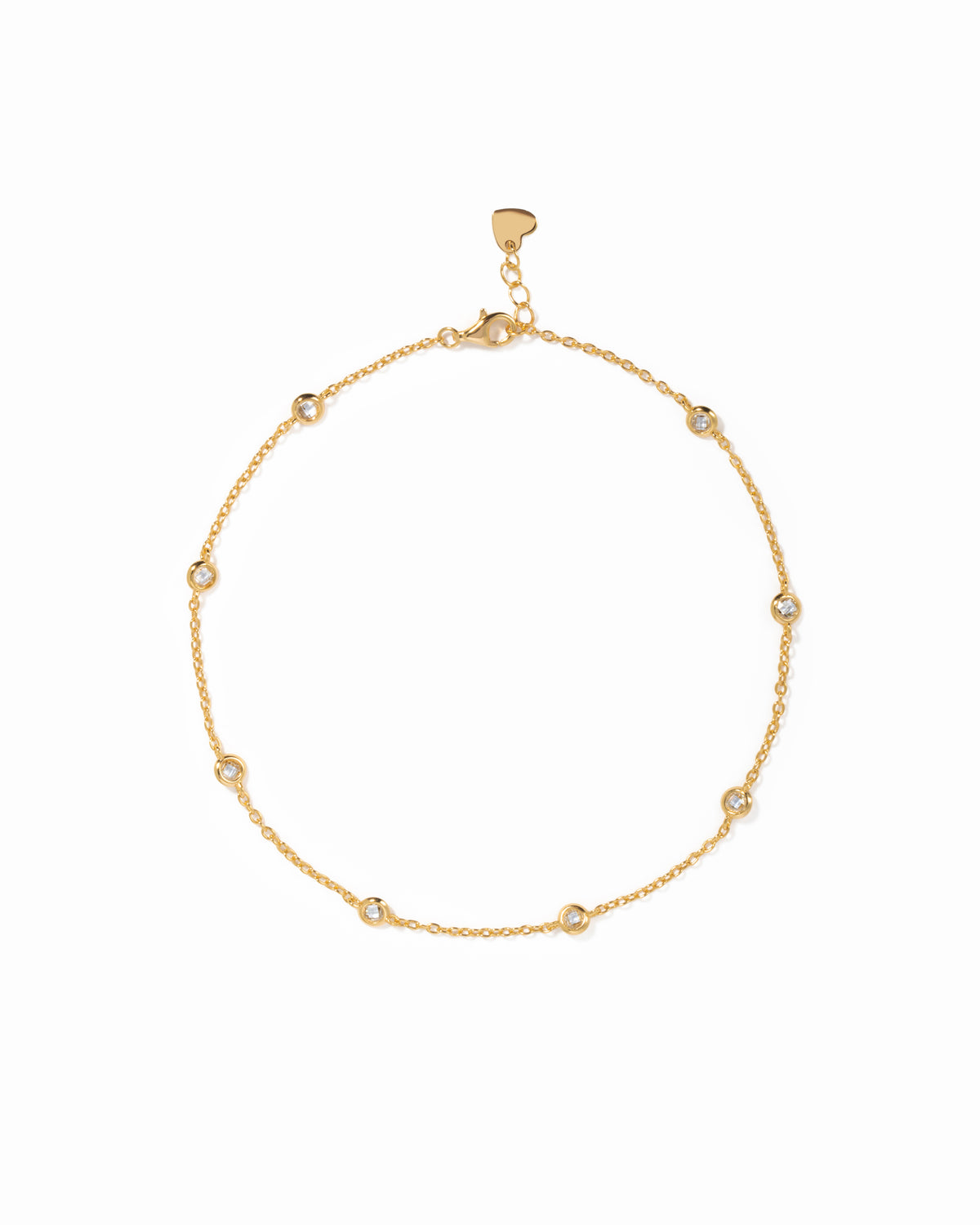 Bezel Set Station Anklet in gold finish, with round bezel-set stones, lobster clasp and heart-shaped end tag.