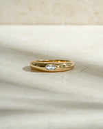 gold bezeled dome ring with cubic zirconia stone on neutral background