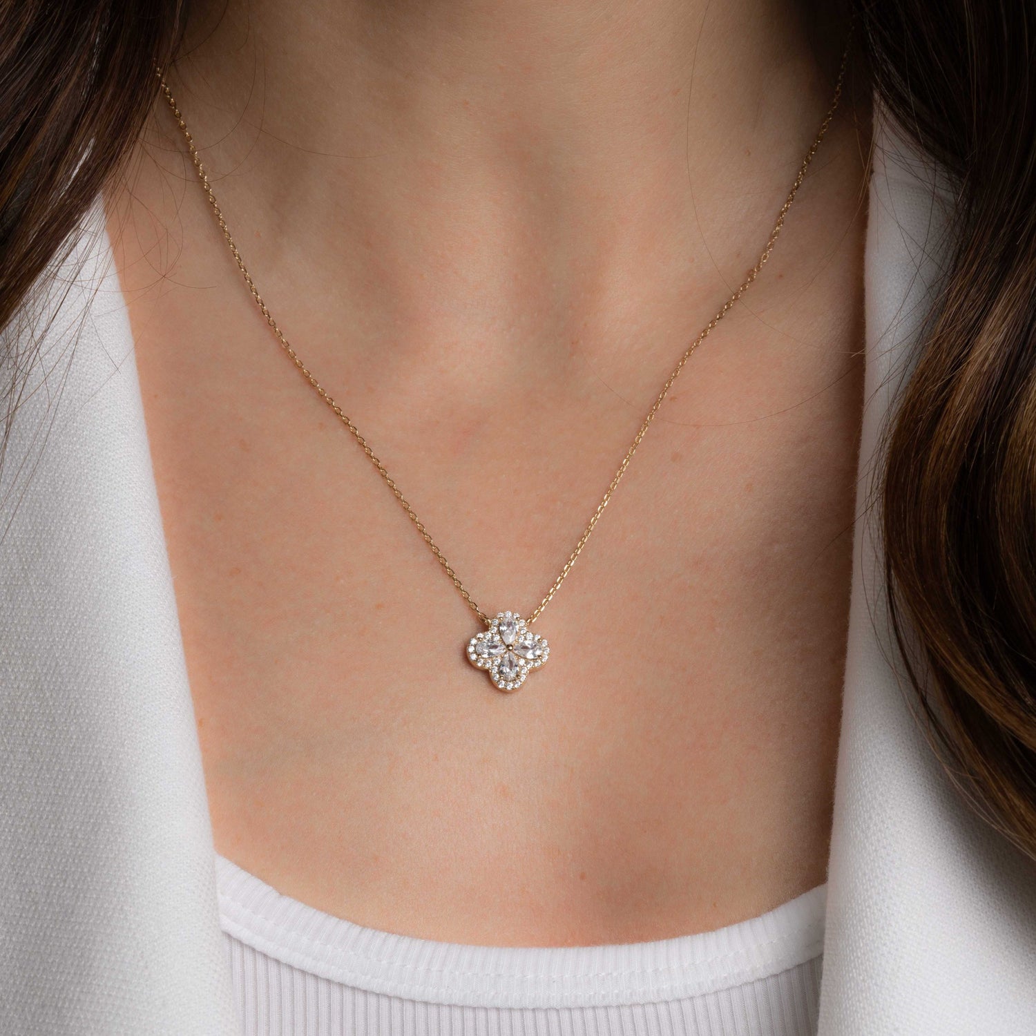 Model wearing delicate diamond four leaf clover necklace with pear stones cubic zirconia pave stones