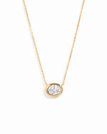 Gold east-west oval CZ bezel pendant necklace on a white background.