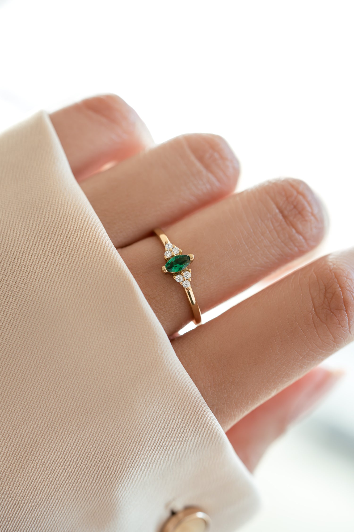 gold diamond emerald marquise ring on models hand 