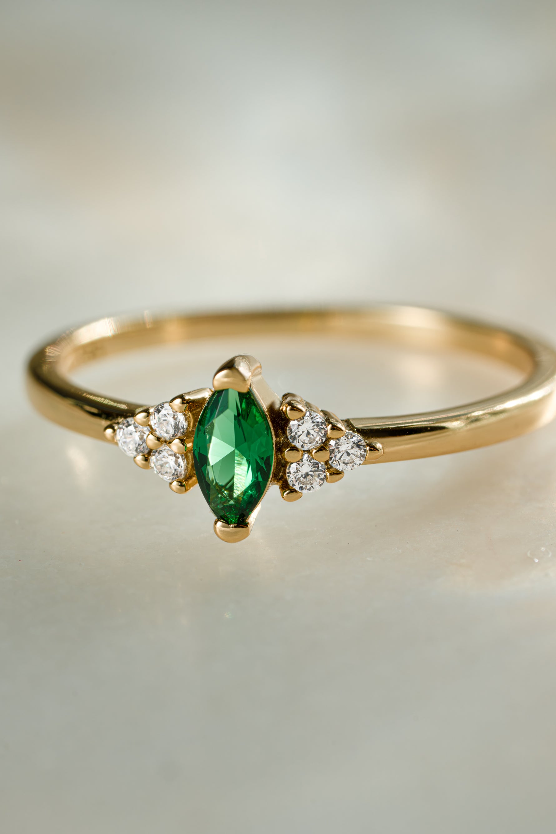 gold diamond emerald marquise ring closeup