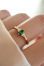 gold diamond emerald marquise ring on models hand