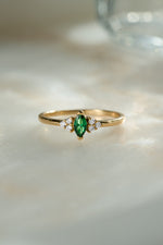 gold diamond emerald marquise ring on neutral background