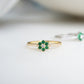 a minimalist gold emerald ring with a flower 