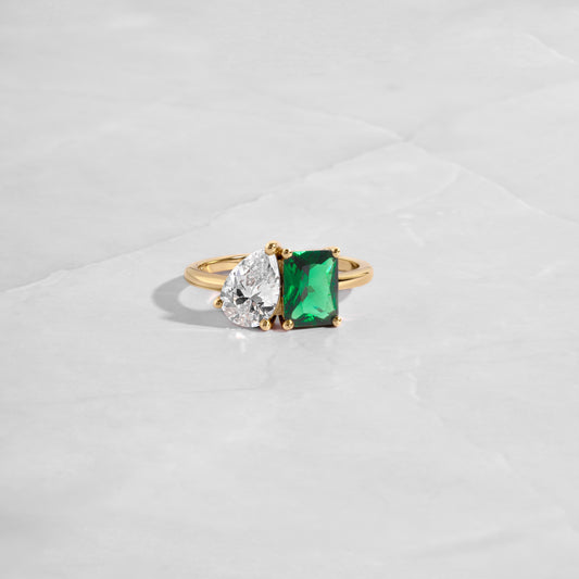 Close-up of the Toi et Moi Ring focusing on the emerald cut and pear stone. 