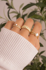 gold diamond eternity ring with gold stackable rings on womens hand