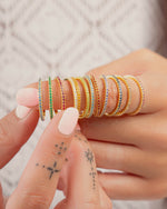 gold eternity birthstone rings on models finger