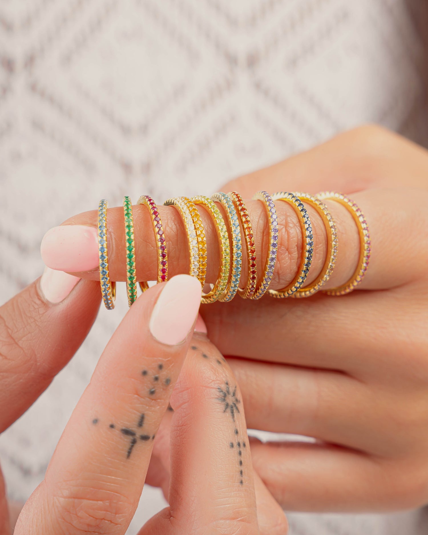 gold eternity birthstone rings on models finger