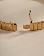 Open gold fluted bangle showing its box clasp tongue and safety latch.