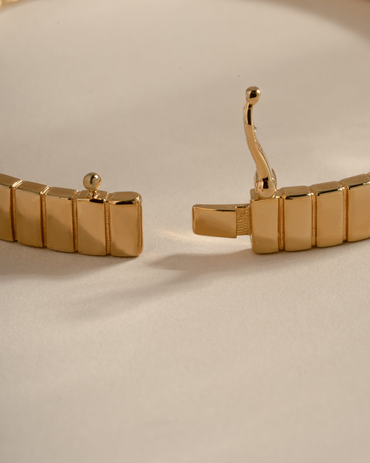 Open gold fluted bangle showing its box clasp tongue and safety latch.