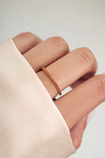 gold garnet eternity ring on womens hand 