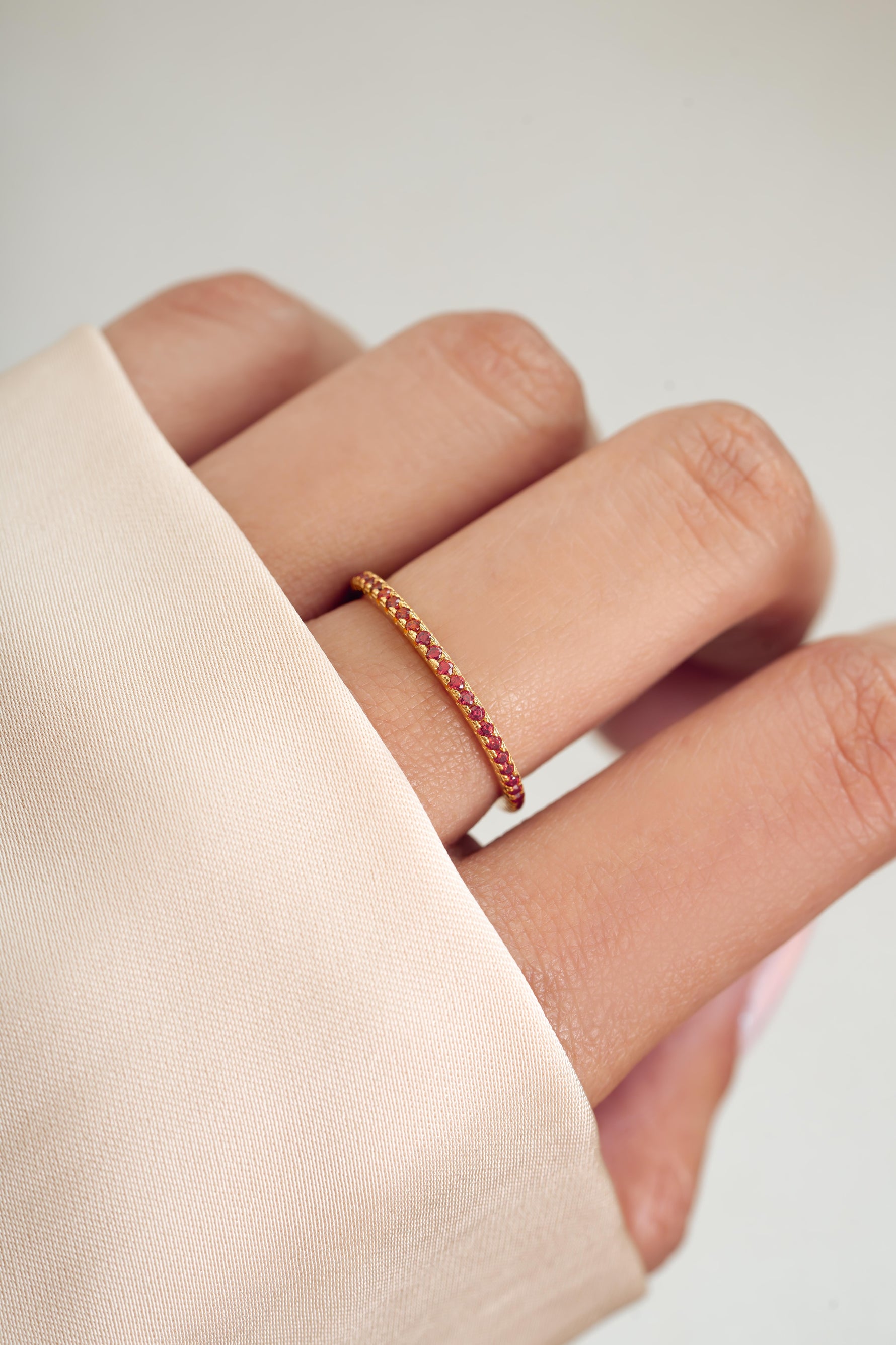 gold garnet eternity ring on womens hand 