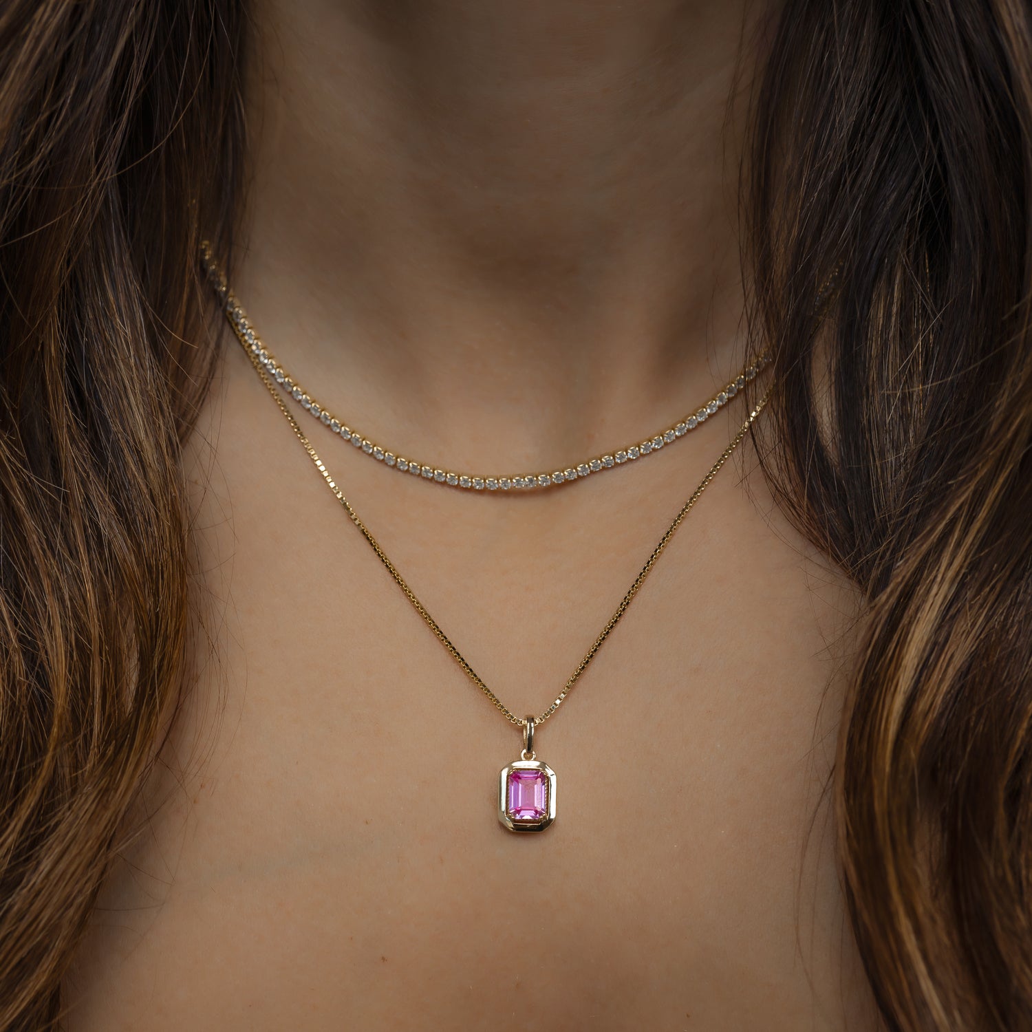 model wearing gold 2mm tennis necklace and pink pendant necklace