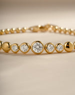 Close-up showing the graduated clear CZ stones and gold bezel settings.