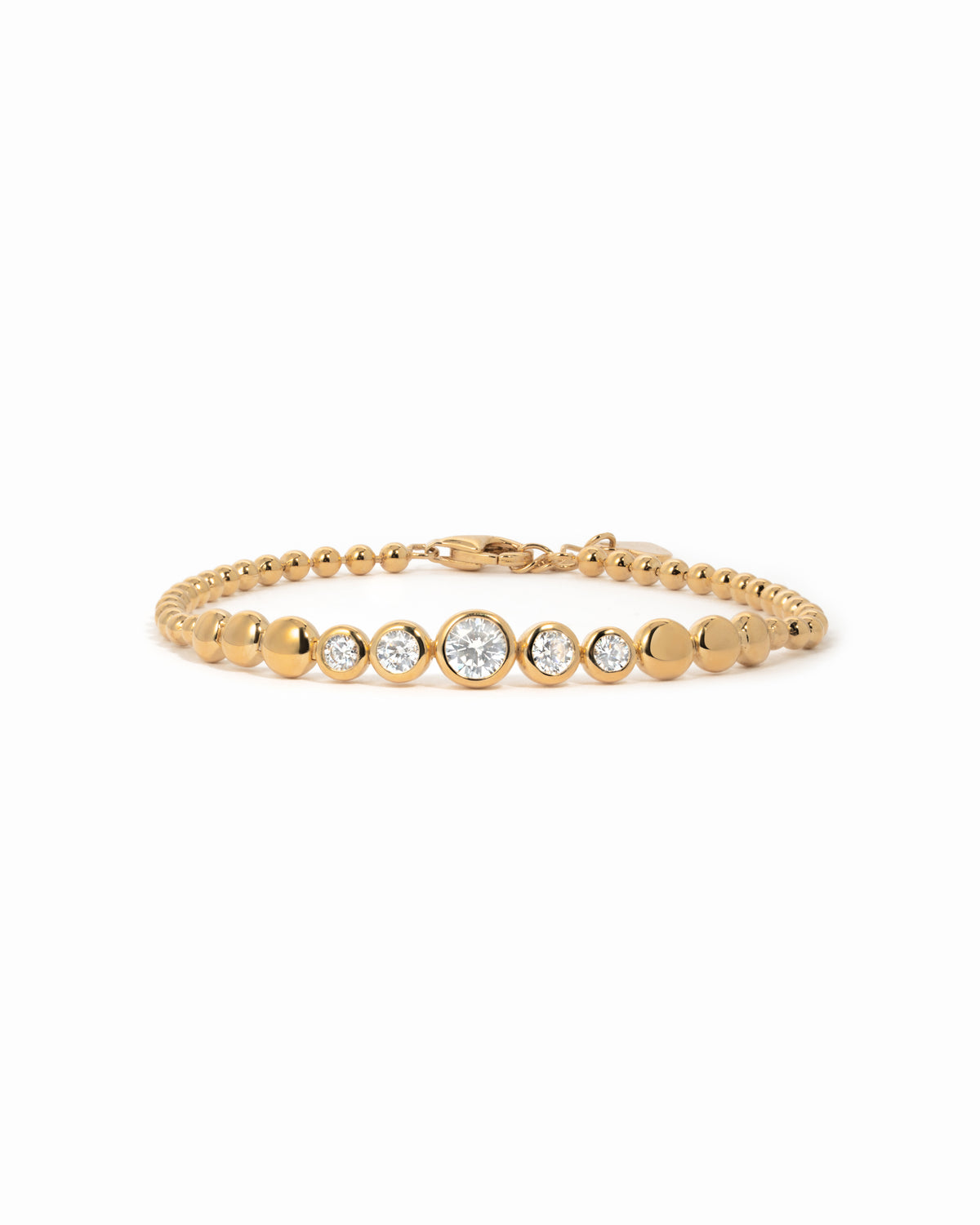 Gold graduated bezel tennis bracelet with clear cubic zirconia on a white background.