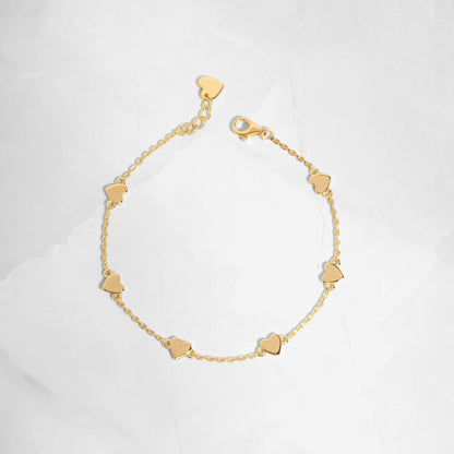 Flat-lay of the love bracelet, highlighting its delicate gold finish and heart charm details.