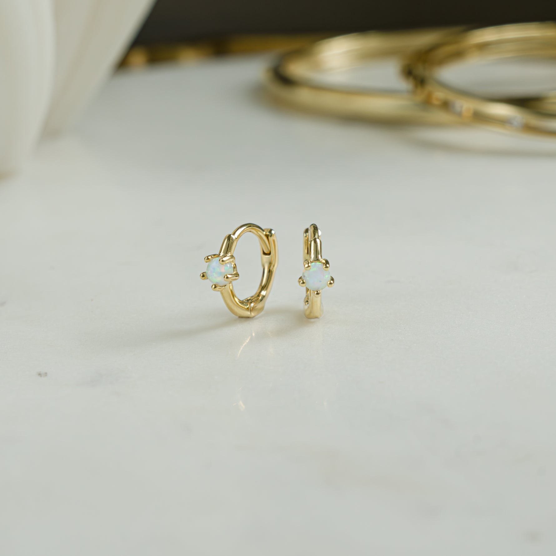 Closeup picture of gold tiny hoop earrings. Perfect birthday gift for her.