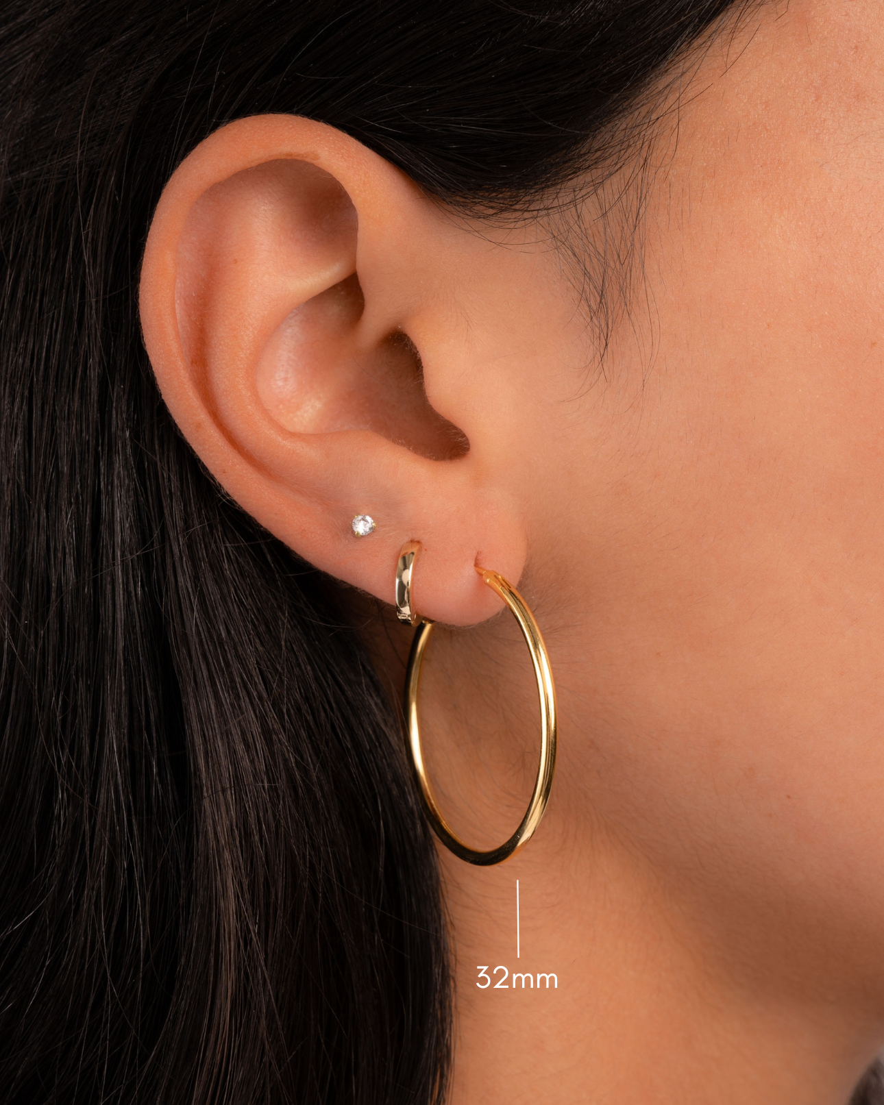 gold 32mm infinity hoop earrings on model