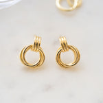 flat lay of gold knot hoop earrings, highlighting its intertwined design
