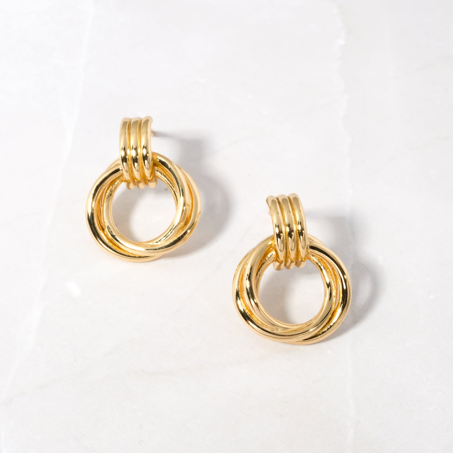 Close-up of Knot Hoop Earrings in gold, featuring a smooth, intertwined knot design.