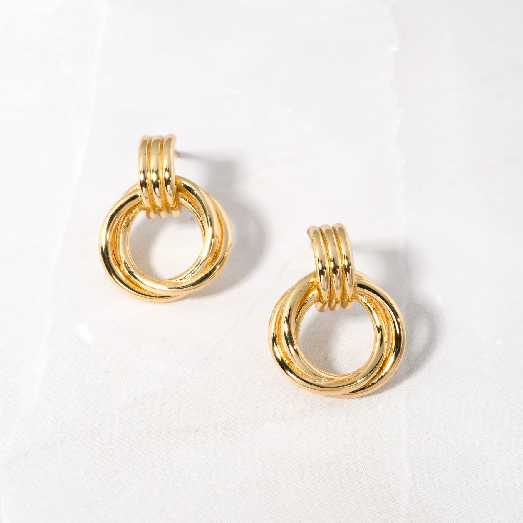 Close-up of Knot Hoop Earrings in gold, featuring a smooth, intertwined knot design.