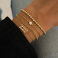 Lucky Number Bracelet plated in gold, with other dainty gold bracelets worn on model